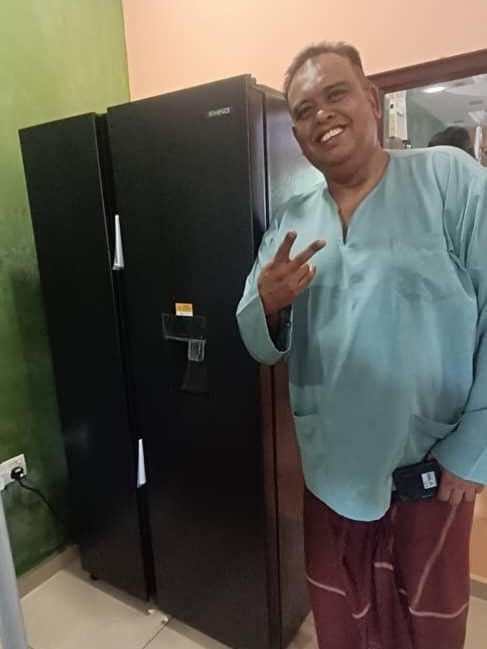 Pelanggan tersenyum lebar di sebelah peti sejuk side-by-side