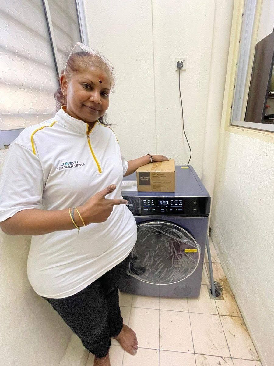 Pelanggan bergaya di sebelah washer dryer Khind