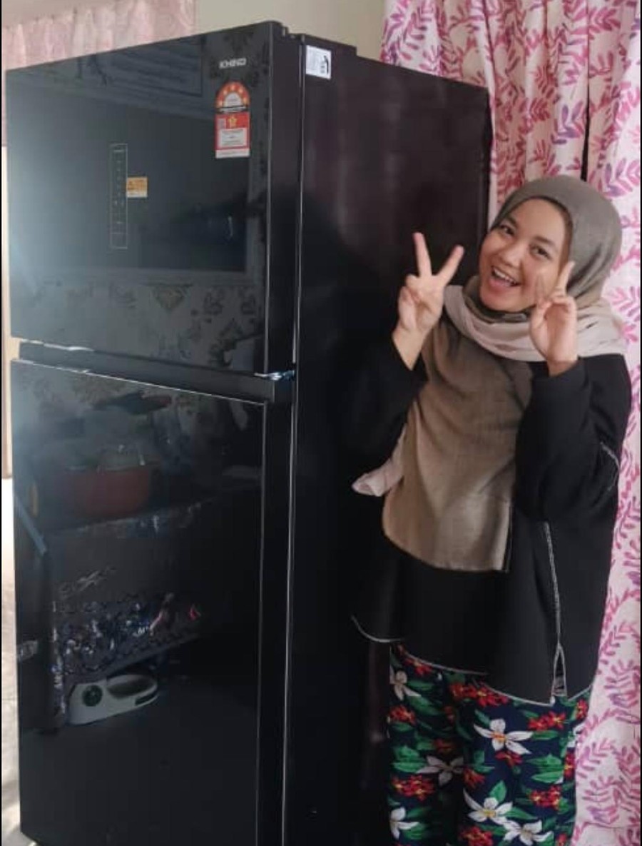 Pelanggan ceria bergaya di sebelah peti sejuk 2 pintu Khind